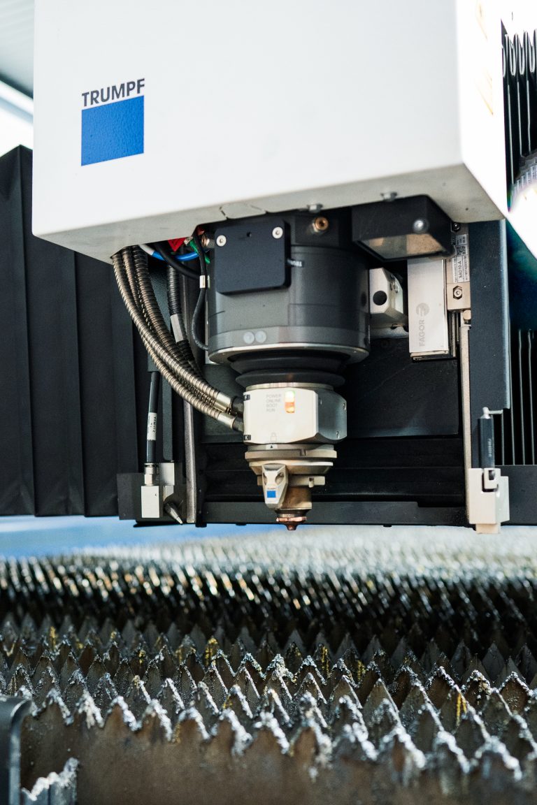 Schneidkopf der Trumpf TruLaser über lasergeschnittenem Blech